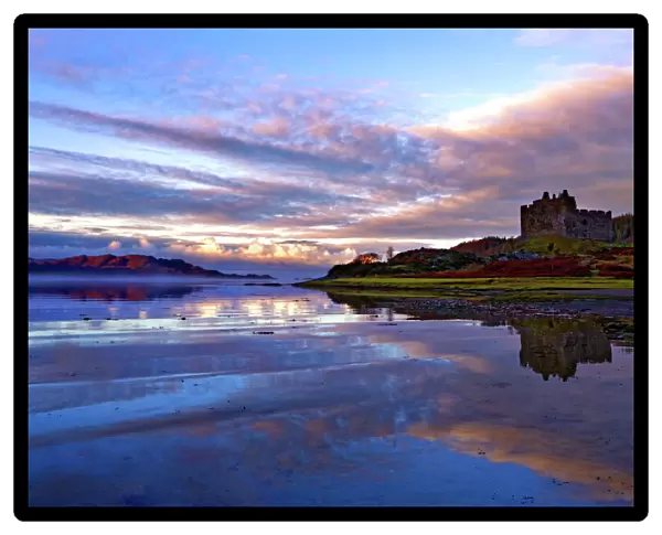 Early morning view of Castle Tioram and Loch Moidart as dawn breaks in a warm colorful