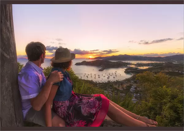Couple look to the English Harbor from Shirley Heights at sunset, Antigua, Antigua and Barbuda
