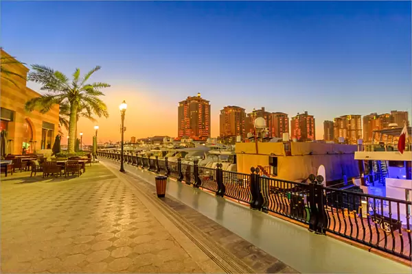 Marina corniche promenade at night in Porto Arabia at the Pearl-Qatar, with residential
