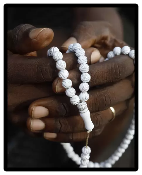Close-up of hands of African Muslim man praying with Islamic prayer beads (tasbih), Togo