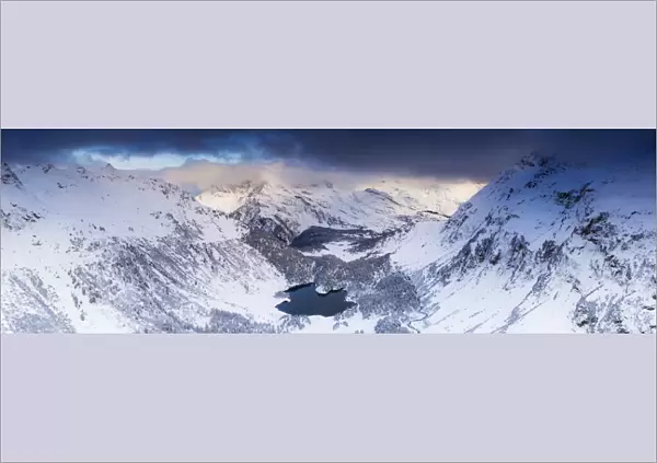Aerial panoramic of Lake Cavloc and snowy woods, Bregaglia Valley, Engadine