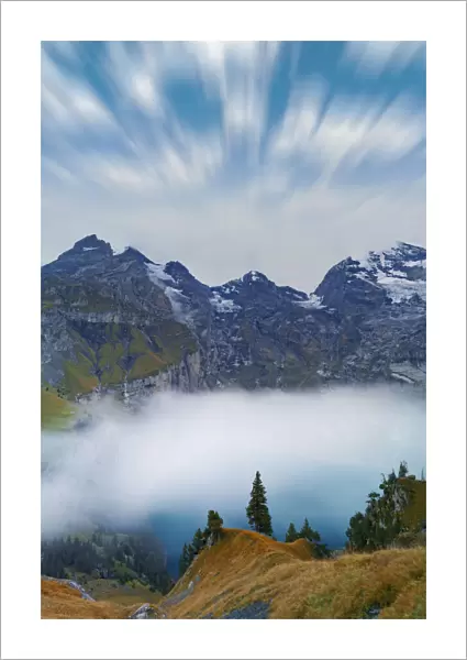 Clouds in the sky above lake Oeschinensee covered by fog, Bernese Oberland, Kandersteg