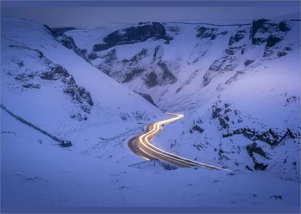 View of trail lights on snow covered Winnats Pass near Castleton, Derbyshire, England, United Kingdom, Europe
