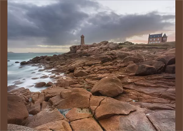 Sunrise long exposure at Ploumanach lighthouse and a house over the pink granite coast, Cotes d Armor, Brittany, France, Europe