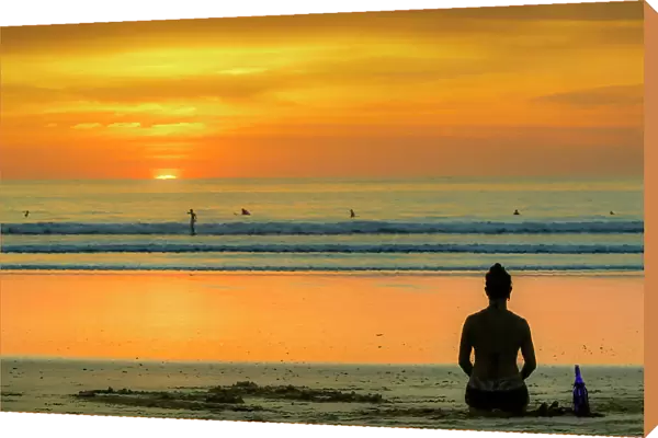Girl and surfers silhouetted by sunset at this hip surf beach and yoga destination, Playa Guiones, Nosara, Guanacaste, Costa Rica, Central America