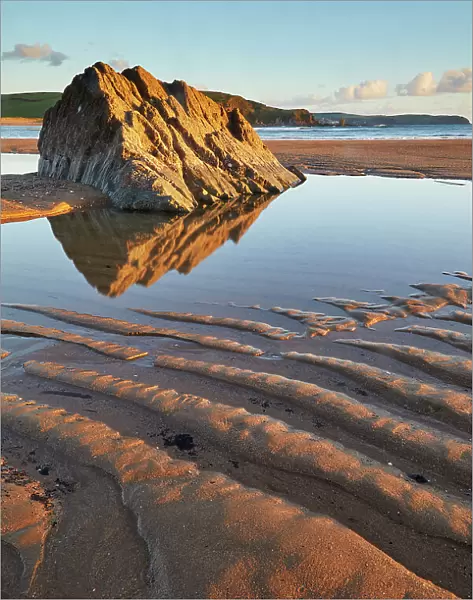A rock pool and rippled sand, on the beach at low tide, at Bigbury-on-Sea, south coast of Devon, England, United Kingdom, Europe