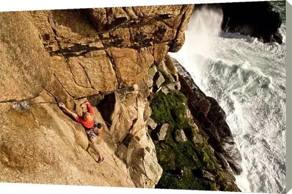 A climber on the classic extreme route Raven Wall on the cliffs at Bosigran, near St