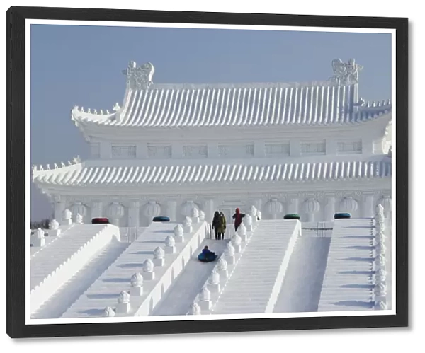 A boy slides down a giant replica sculpture of Beijings Forbidden City at the Snow