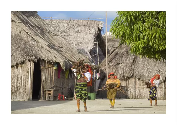 Kuna women carrying wood through village, Wichub-Wala Island, San Blas Islands