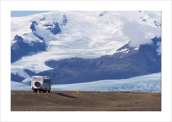 A tourist bus on the ring road (Route 1) beneath the huge mass of Oraefajokull