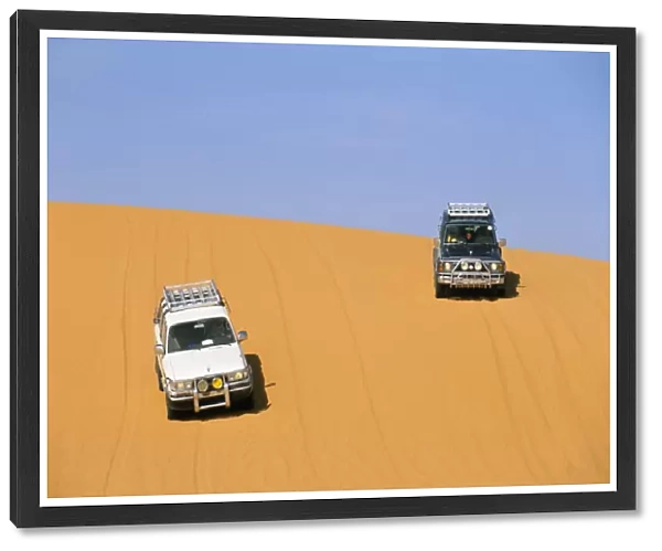 Jeeps on sand dune, Akakus, Sahara desert, Fezzan, Libya, North Africa. Africa