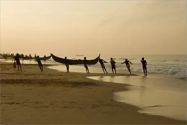 Fishermen hauling in nets at sunrise, Chowara Beach, near Kovalam, Kerala, India, Asia