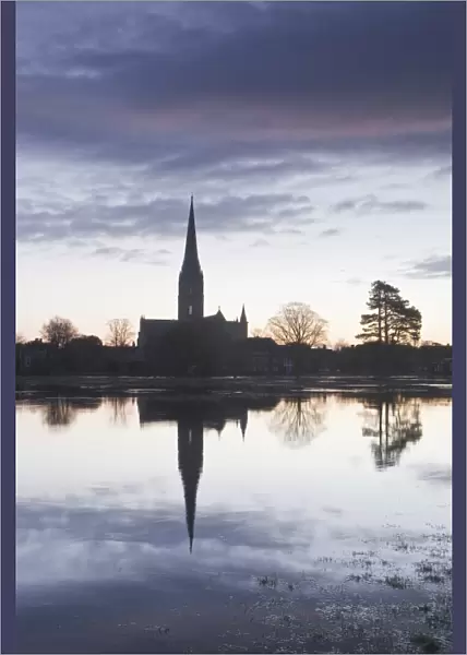 Salisbury cathedral at dawn reflecting in the flooded West Harnham Water Meadows, Salisbury, Wiltshire, England, United Kingdom, Europe