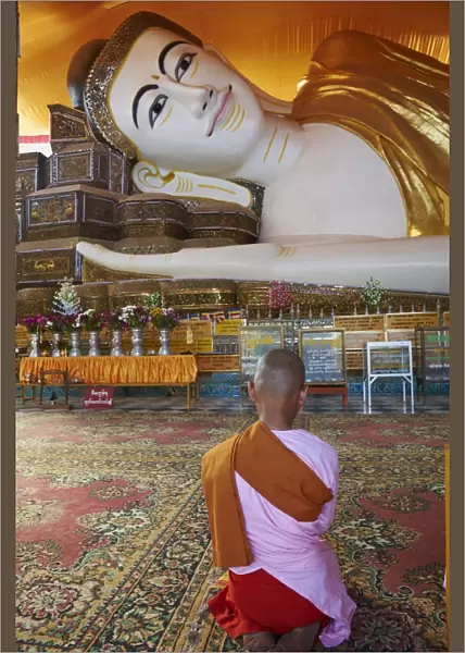 Nun in front of reclining Buddha statue, Shwethalyaung, Bago (Pegu), Myanmar (Burma), Asia