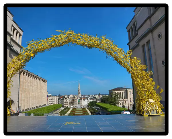 Yellow Arch of bicycles at the Mont des Arts Gardens and Tower of the Town Hall, Brussels