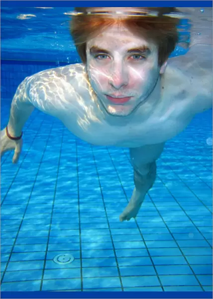 Man swimming underwater in a swimming pool