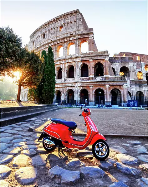 Italy, Rome, a red Vespa motorbike in front of Colosseum at sunrise