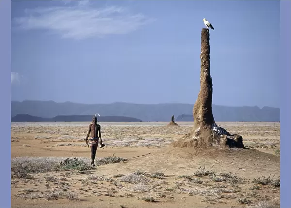 A Turkana man strides purposefully across the treeless