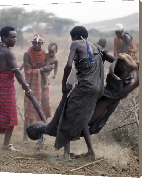 A Samburu youth is forcibly restrained after throwing