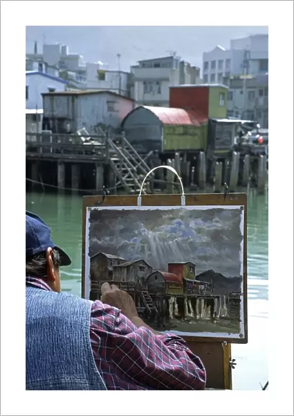 An artist at work painting the stilt house village