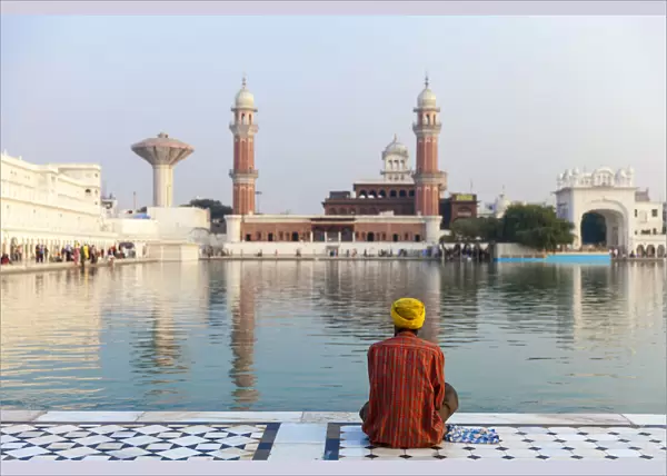India, Punjab, Amritsar, Pilgrim sitting infront of The Harmandir Sahib, known as