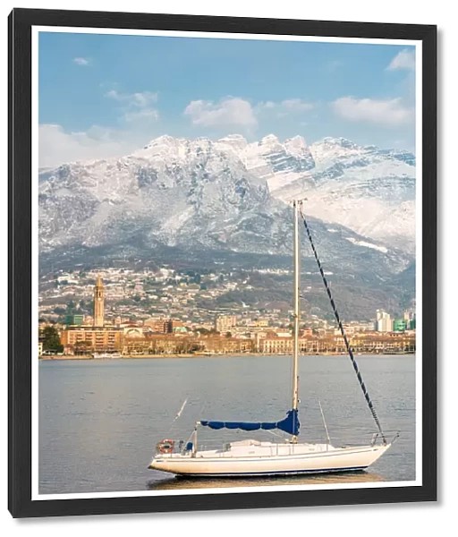Close up of a boat on Lecco lake with Lecco city and Resegone mount in the background