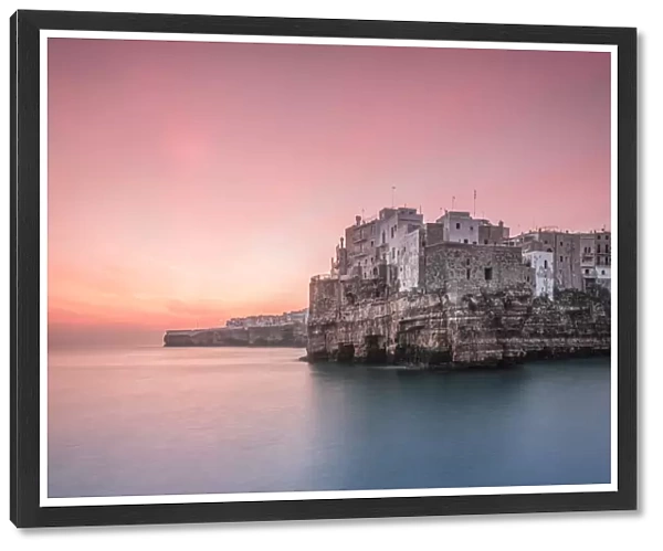 Old town of Polignano a Mare built on rocky cliffs at sunrise, Bari province, Apulia