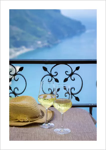 Amalfi Coast, Italy, a table for two, a summer hat and two glasses of white wine with
