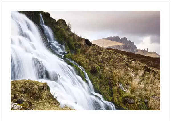 A waterfall with the Old Man of Storr in the background, Isle of Skye, Scotland, UK
