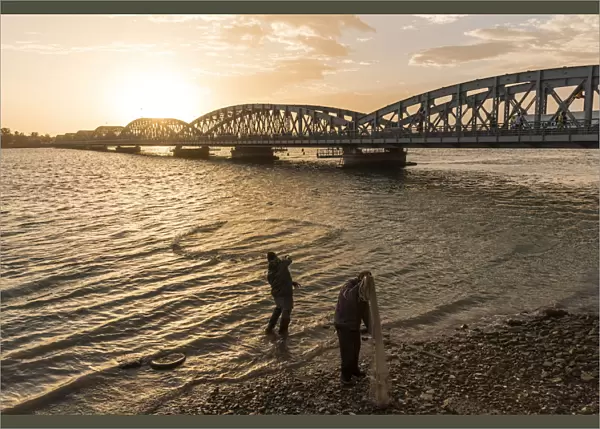 Africa, Senegal, Saint-Louis. Fishermen with nets at the Faidherbe bridge