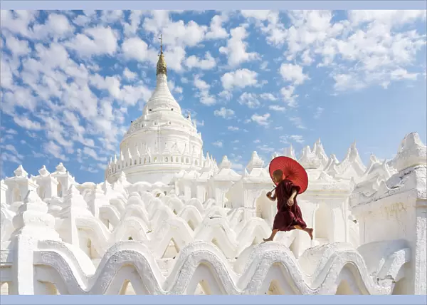 Novice monk running and jumping at Hsinbyume pagoda, Mingun, Mandalay, Sagaing Township