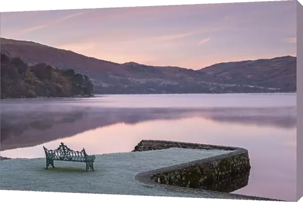 Bench on Ullswater at dawn on a frosty winter morning, Lake District, Cumbria, England