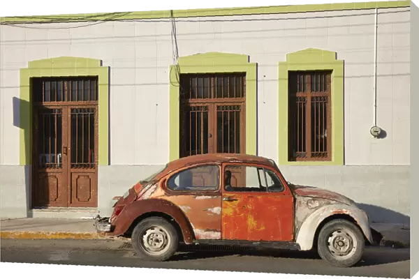 A vintage Volkswagen Beetle in front of a house in Merida, Yucatan, Mexico