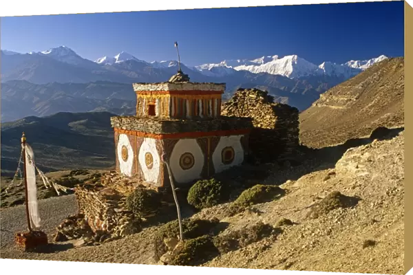 Nepal, Himalaya, Mustang. A decorative chorten, or Buddhist shrine, known as Chhyungkar guards the trail near Syangboche hamlet and the Syangboche Pass while the massive Annapurna massif frames