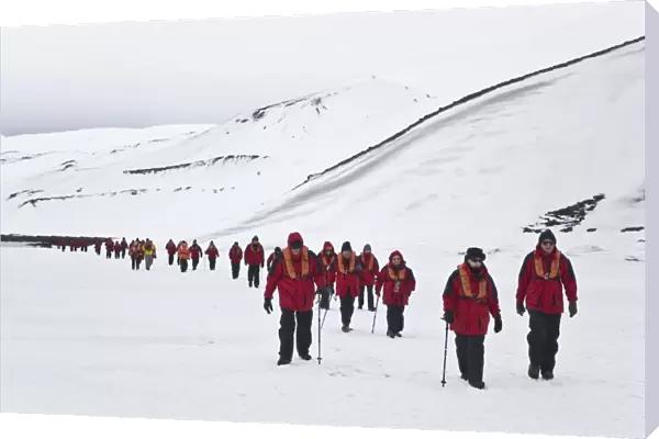 Lindblad Expeditions guests hiking on shorefast ice inside the caldera on Deception Island in Antarctica as part of expedition travel. NO MODEL RELEASES FOR THIS IMAGE
