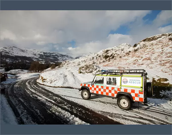 A landrover belonging to the Langdale Ambleside Mountain Rescue Team in winter snow in front of the Langdale Pikes Cumbria