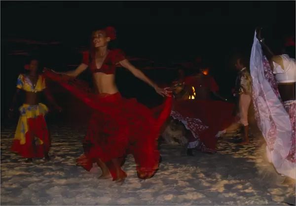 10078942. MAURITIUS Sega Dancers Women in red costume dancing on the beach at night