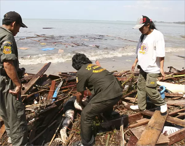Tsunami. Rescue workers help to collect the bodies which have been floating out at sea and lying along the coastline. Bodies that were out at sea now litter the coastline. Now the devestation can be seen in the remote areas