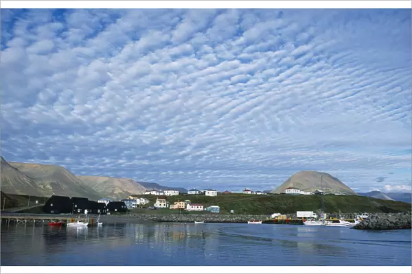 Iceland, Skagafjorour, Hofsos Island, Seaside village with boats on water and houses built along shoreline