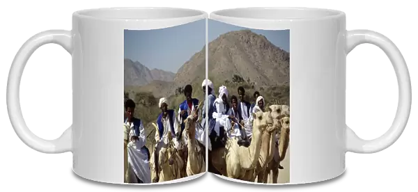 20040128. ERITREA Nomadic People Nomads riding camels on road between keren