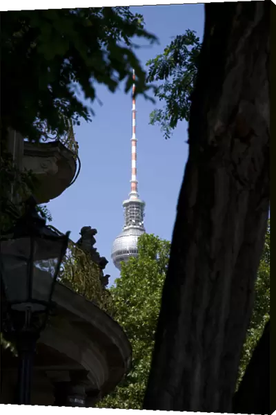 Germany, Berlin, Mitte, The Fernsehturm TV Tower near Alexanderplatz seen through trees