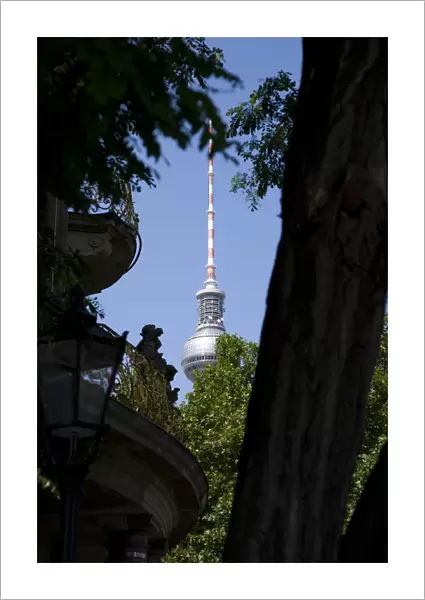 Germany, Berlin, Mitte, The Fernsehturm TV Tower near Alexanderplatz seen through trees