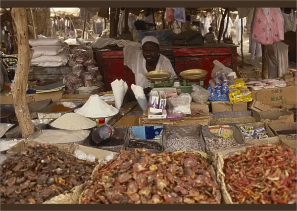 20075228. SUDAN North Darfur El Fasher Market trader sitting behind scales