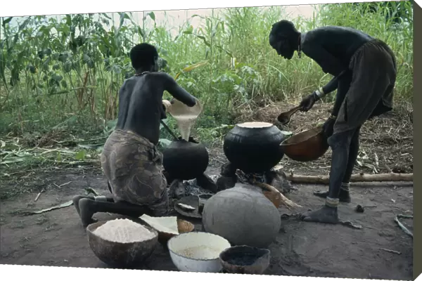 20075325. SUDAN Tribal People Dinka women cooking millet
