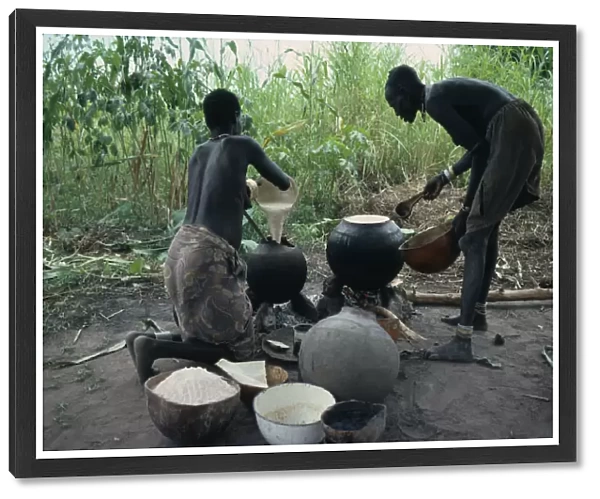 20075325. SUDAN Tribal People Dinka women cooking millet