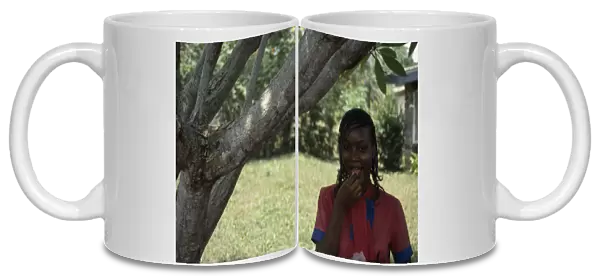 20085672. NIGERIA Ibadan Portrait of Yoruba girl eating groundnuts
