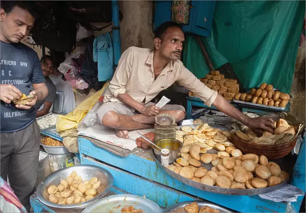 India, West Bengal, Kolkata, A vendor selling snack food including samosas, kachori, and pani puri