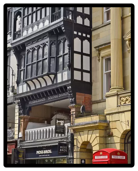 England, Cheshire, Chester, Iconic red telephone box converted to ATM on Eastgate Street with black and white architecture behind