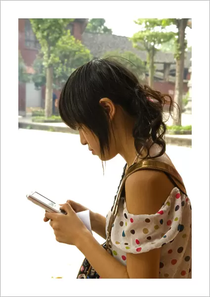 CHINA, Sichuan Province, Chongqing Girl using a mobile phone