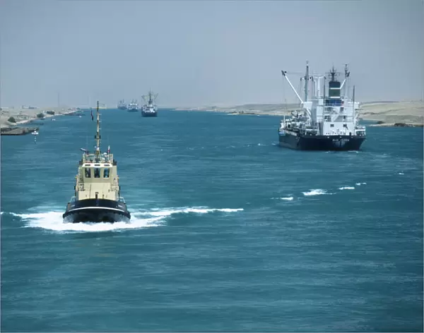 10007961. EGYPT Suez Canal Looking down Canal with tug approaching and ships moving away